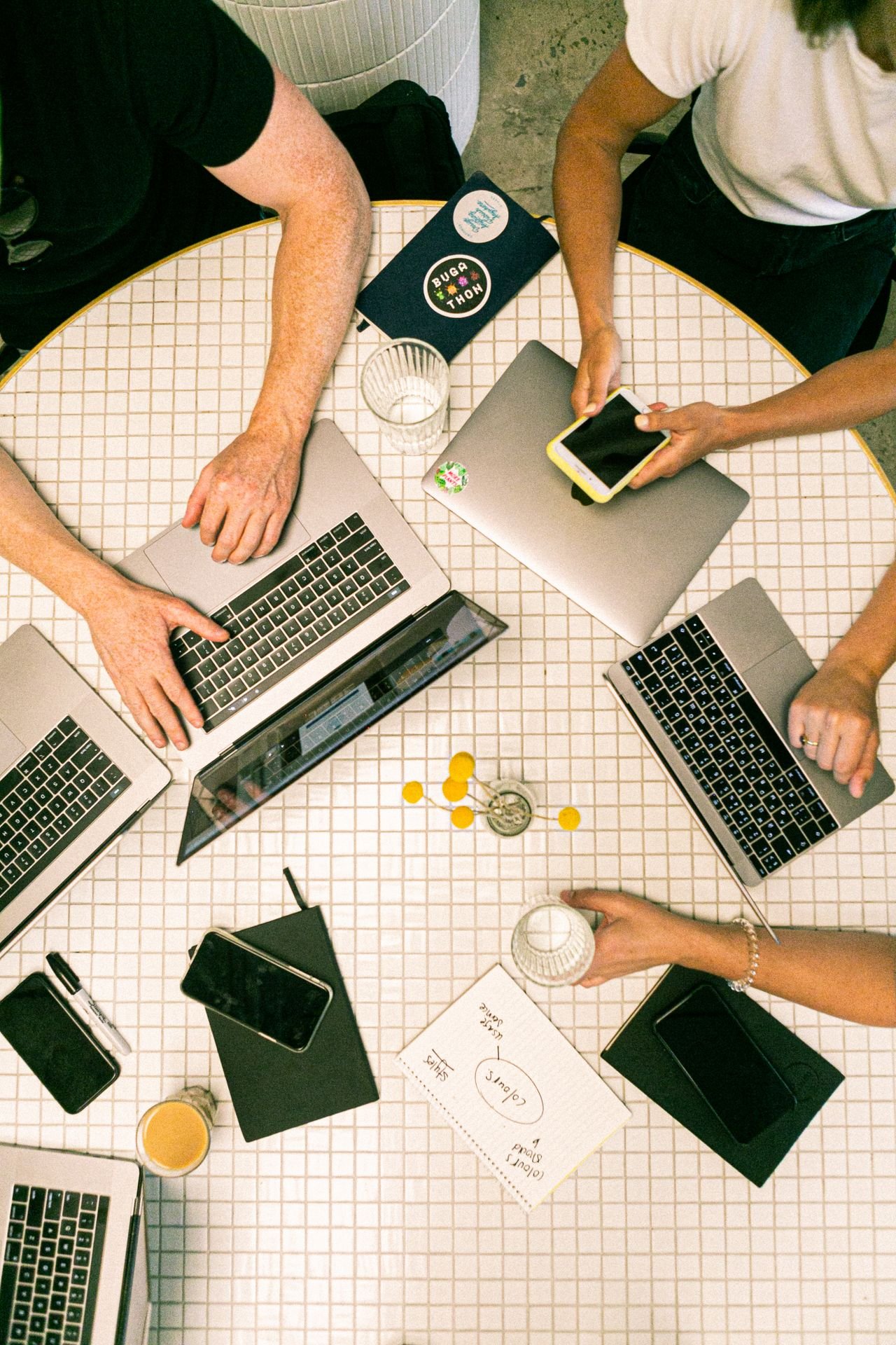 Overhead view of a team collaborating with laptops at a round table